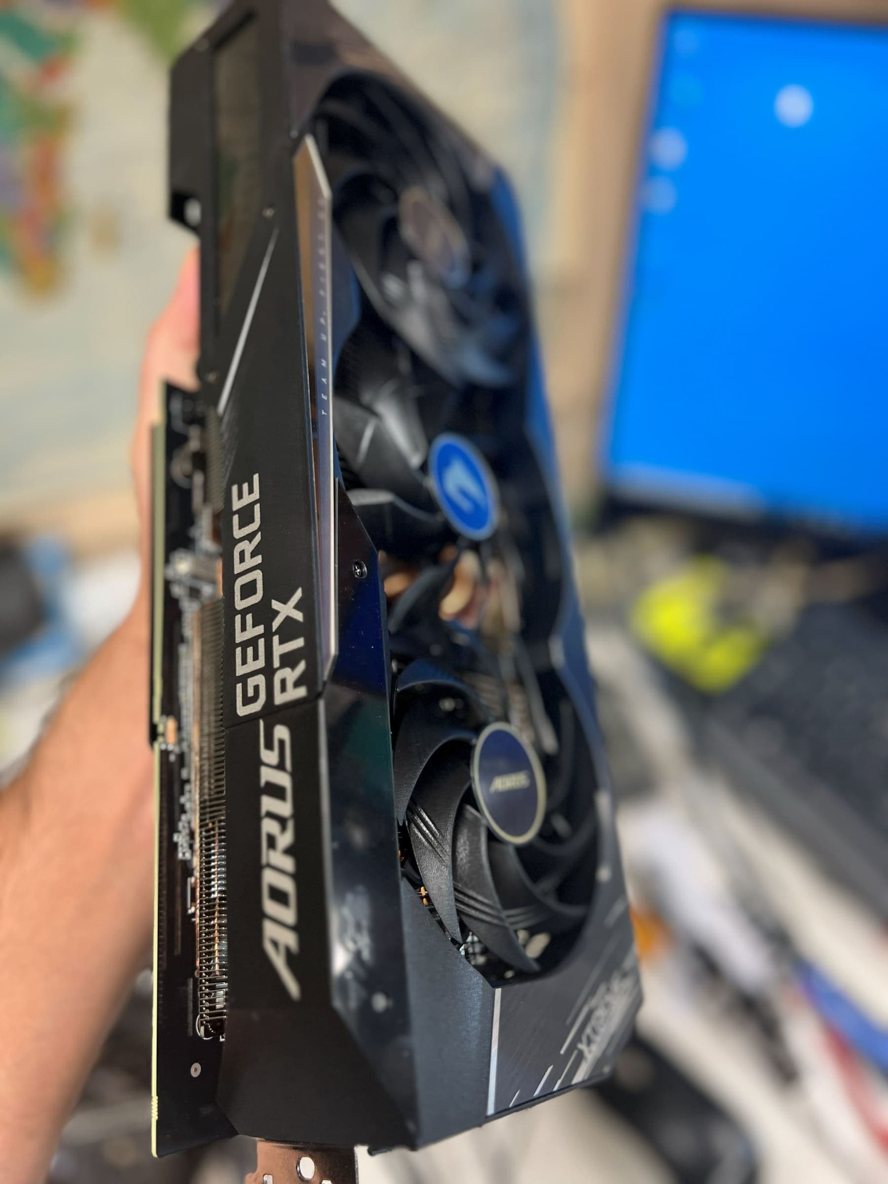 Aorus graphics card being installed during a hardware upgrade at Technoland